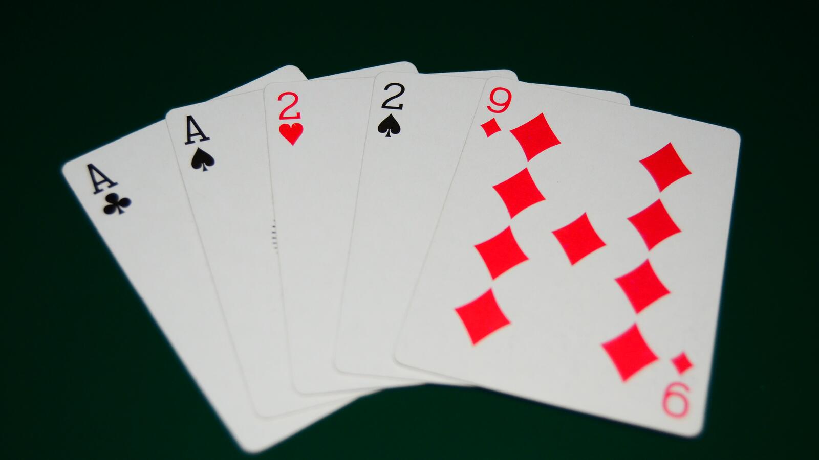 Pokerhand med fem spelkort på grönt bord